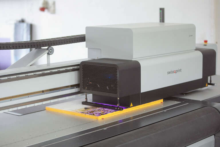 Der swissQprint Digitaldrucker des Fotolabor Trenkle Freiburg im Breisgau druckt gerade ein Heimatfoto aus dem Nordschwarzwald im UV-Direktdruckverfahren