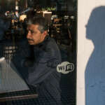 Mann sitzt in Restaurant, Schatten an der Wand - Ein Foto von Journalist, Fotograf und GATE7 Podcaster Kai Behrmann - bei uns zu Gast im Heimatlichter-Podcast
